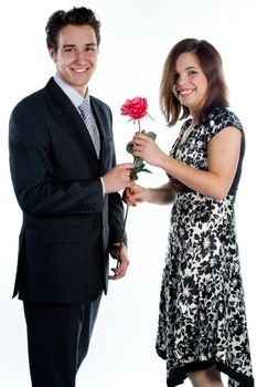 A young man gives a beautiful young woman, a flower in honor of the holiday