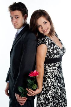 A young man gives a beautiful young woman, a flower in honor of the holiday