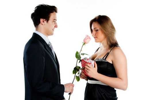 A young man gives a beautiful young woman, a flower in honor of the holiday