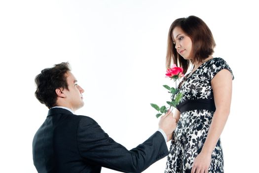 A young man gives a beautiful young woman, a flower in honor of the holiday