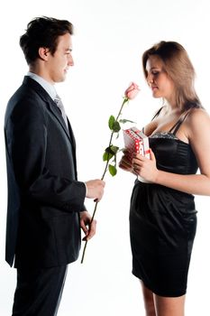 A young man gives a beautiful young woman, a flower in honor of the holiday