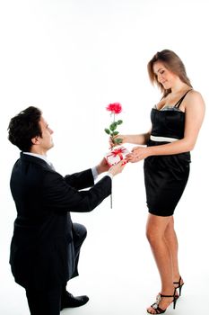 A young man gives a beautiful young woman, a flower in honor of the holiday