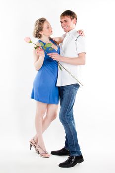 A young man gives a beautiful young woman, a flower in honor of the holiday