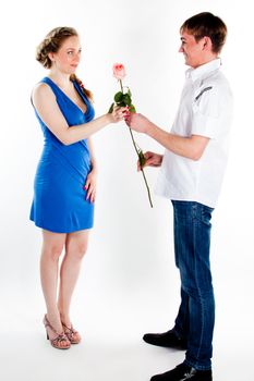 A young man gives a beautiful young woman, a flower in honor of the holiday