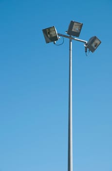 stadium lights pole against blue sky background