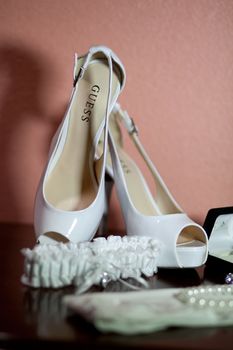 Bride's wedding shoes and other details against a wall