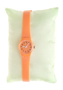 orange rubber and plastic watch on green pillow (isolated on white background)