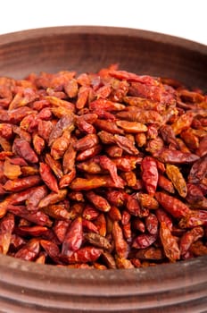 Piri Piri peppers on a vintage wooden bowl (close-up picture, isolated on white background)