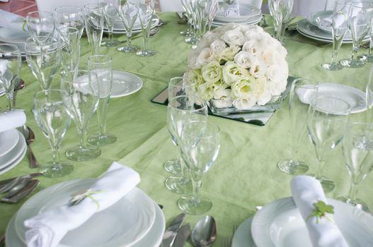 detail of a wedding table set for fine dining with a estomas arrangement