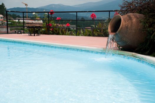 beautiful swimming pool detail with a ceramic terracota vase as a cascade