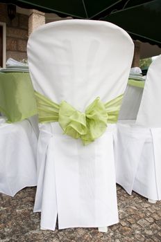 gorgeous wedding chair decorated with a green ribbon at outdoors