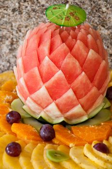 decorated fruit table setting with watermelon, grapes, orange and pineapple slices