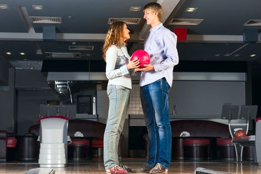 guy hugs her friendgirl, playing together in bowling