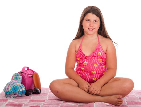 beautiful brunette teenage girl in swimsuit at the beach (studio setting with bag, cap, towel, sun lotion, sunglasses) isolated on white background