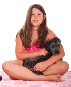 smiling brunette teenage girl in swimsuit at the beach with her shipoo dog (studio setting with pink towel) isolated on white background
