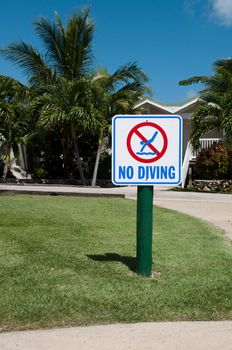 no diving sign on the grass (tropical resort setting with palm trees)