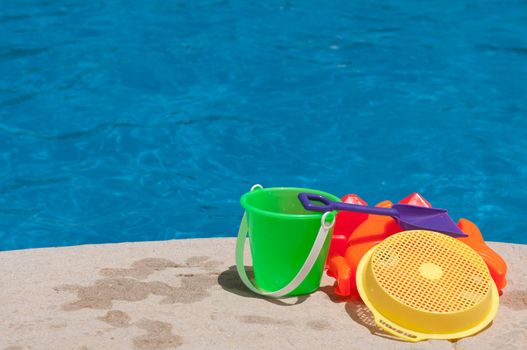 bright and colorful children toys at poolside (family vacations concept)