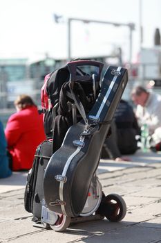 The luggage of a musician located on a street in Venice near the sea in a sunny day.