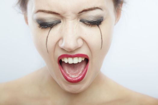 Close-up portrait of the crying and screaming lady with painted tears