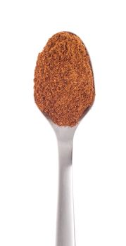 garam masala spice on a stainless steel spoon, isolated on white background