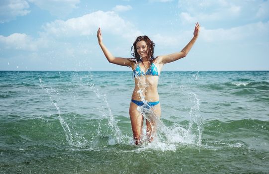 Happy lady in vacation playing with water