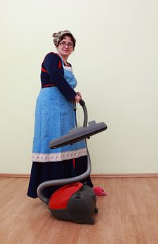 Housewife using a vacuum cleaner to clean the floor.