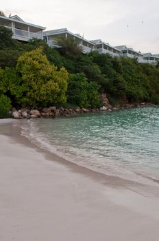 sunset picture of a tropical beach and resort villas in Willikies, Antigua