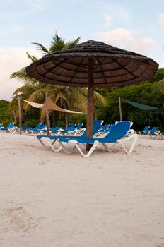 beach chairs and umbrella on a tropical beach resort in Antigua (sunset picture)