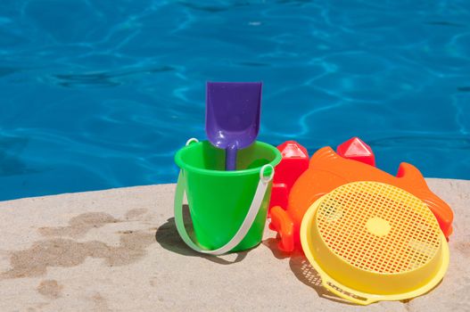 bright and colorful children toys at poolside (family vacations concept)