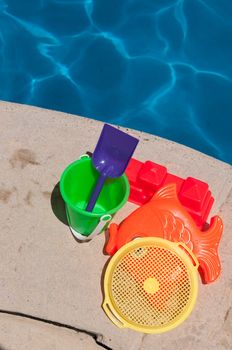 bright and colorful children toys at poolside (family vacations concept)