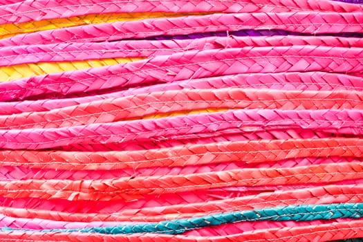 Close up of a stack of colorful straw hats as a a background