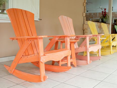 colorful wooden rocking chairs on a porch (usual setting on a tropical resort)