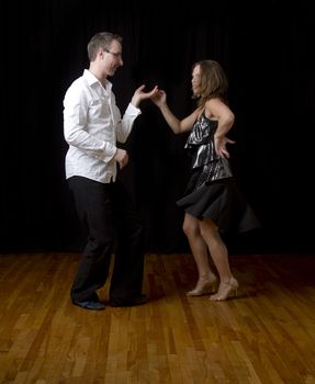 couple dancing salsa in the middle of a pose