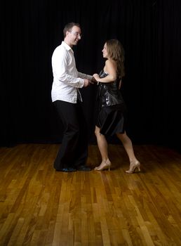 couple dancing salsa in the middle of a pose