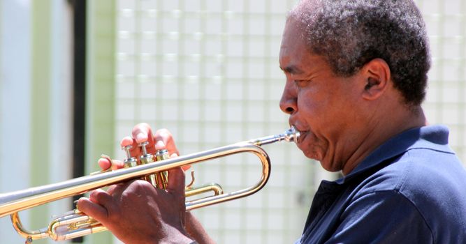 Jazz trumpet player blowing his horn outside.