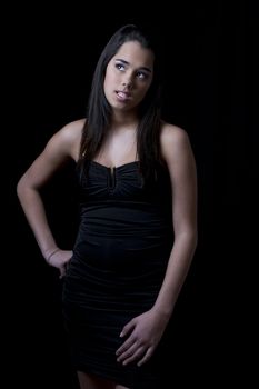 Teenage girl giving attitude and looking up in a little black dress