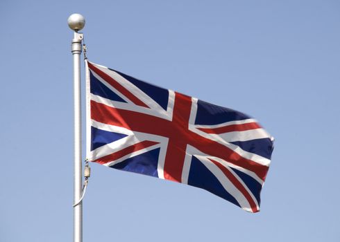 British Union Jack against blue sky, blowing in the breeze, movement  of flag.