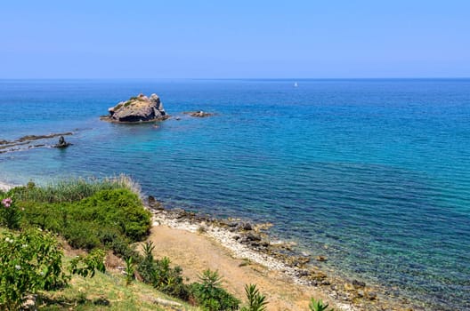 Landscape with pebble beach and rocky island