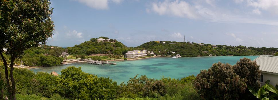 panoramic picture of Antigua Long Bay, gorgeous view surrounded by tropical nature and some typical houses