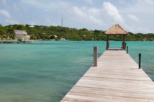 tropical wooden jetty with hut over sea in Long Bay, Antigua