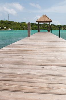 tropical wooden jetty with hut over sea in Long Bay, Antigua