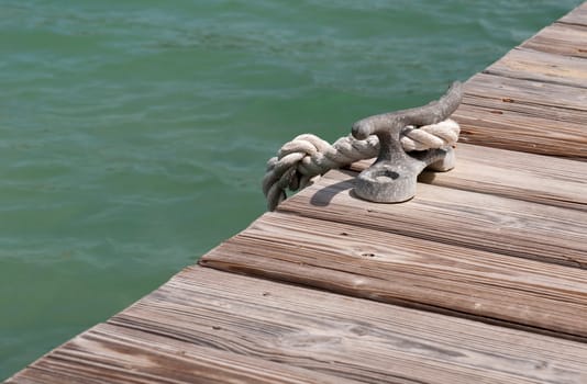 old iron mooring cleat on a wooden pier (green lagoon)