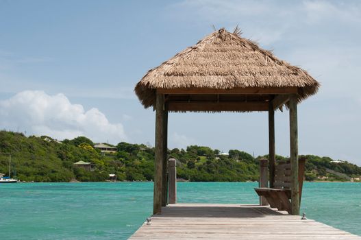 tropical wooden jetty with hut over sea in Long Bay, Antigua