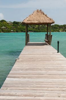 tropical wooden jetty with hut over sea in Long Bay, Antigua