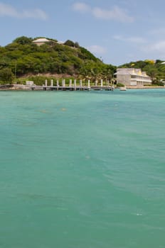 Antigua Long Bay, gorgeous seascape view surrounded by tropical nature and some typical houses