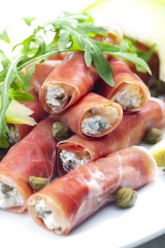 Parma ham rolls filled with cream cheese, Galia melon and capers