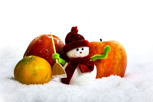 Toy of the snowman and apple in snow