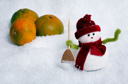 Toy of the snowman and apple in snow