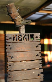 The wooden menu with old a boot above