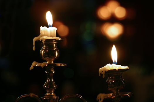 Burning candles in ancient gold candelabrum
